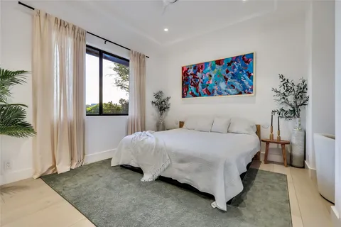 a bedroom with a bed and a painting on the wall