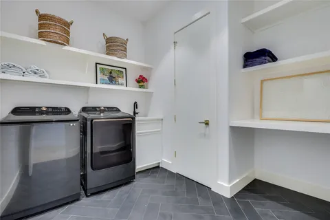 a view of an empty room with wooden floor and cabinets