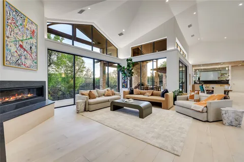 a living room with furniture fireplace and large windows