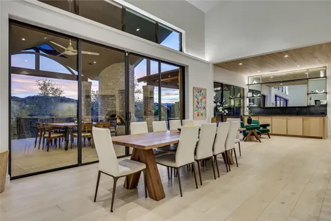 a dining area with furniture a rug and a large window