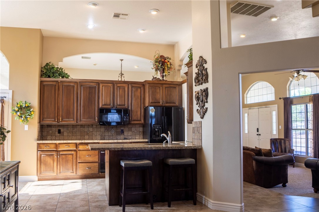2775 Taylor Street Logandale, NV 89021 - Photo 17 of 41 This spacious kitchen with warm wood cabinetry flows seamlessly into an inviting living area.