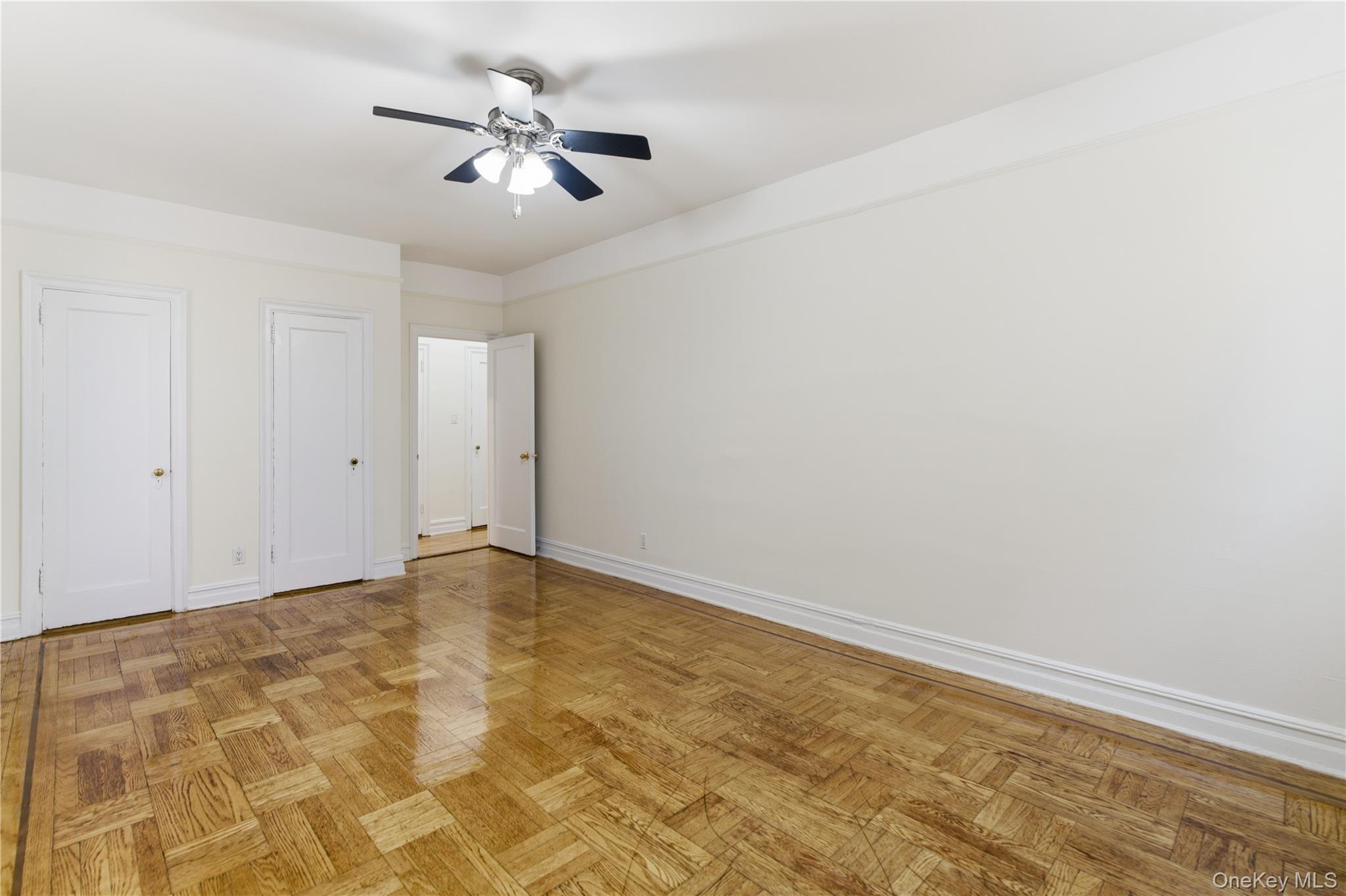 34-20 83rd Street, Unit 2D Queens, NY 11372 - Photo 3 of 11 Unfurnished bedroom with multiple closets and a ceiling fan