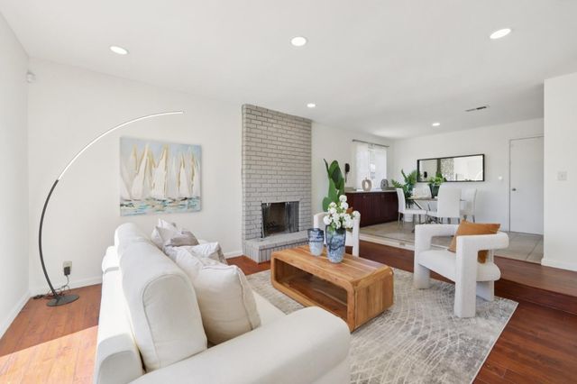 a living room with fireplace furniture and a wooden floor