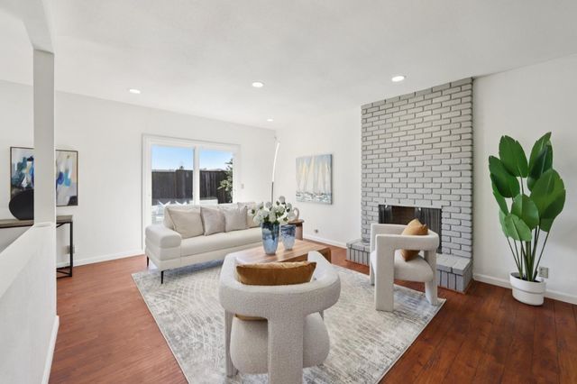 a living room with furniture a fireplace and a potted plant