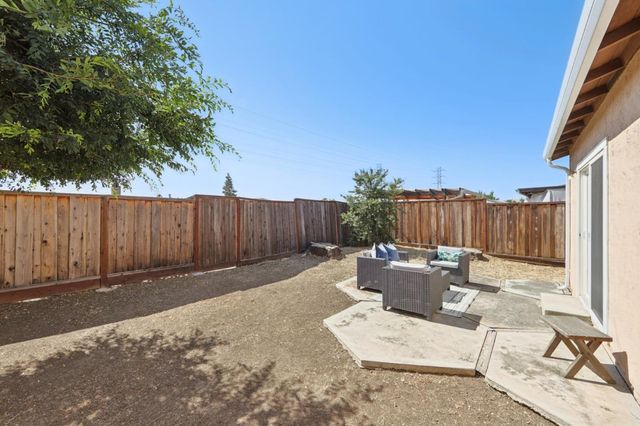 a backyard of a house with trees and wooden fence