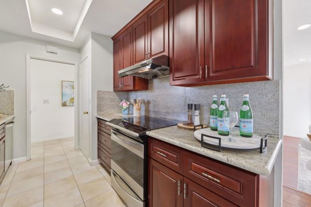 a kitchen with stainless steel appliances granite countertop wooden cabinets a stove top oven a sink and dishwasher