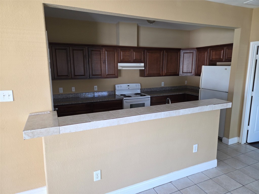 7709 Rhobell Street, Unit B Houston, TX 77016 - Photo 5 of 21 a kitchen with a refrigerator and a stove