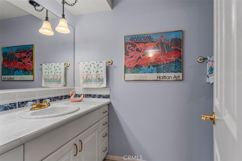 19512 Sierra Mia Road Irvine, CA 92603 - Photo 31 of 46 a bathroom with a sink mirror and painting on the wall