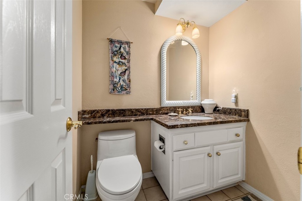 19512 Sierra Mia Road Irvine, CA 92603 - Photo 33 of 46 a bathroom with a granite countertop toilet sink and mirror