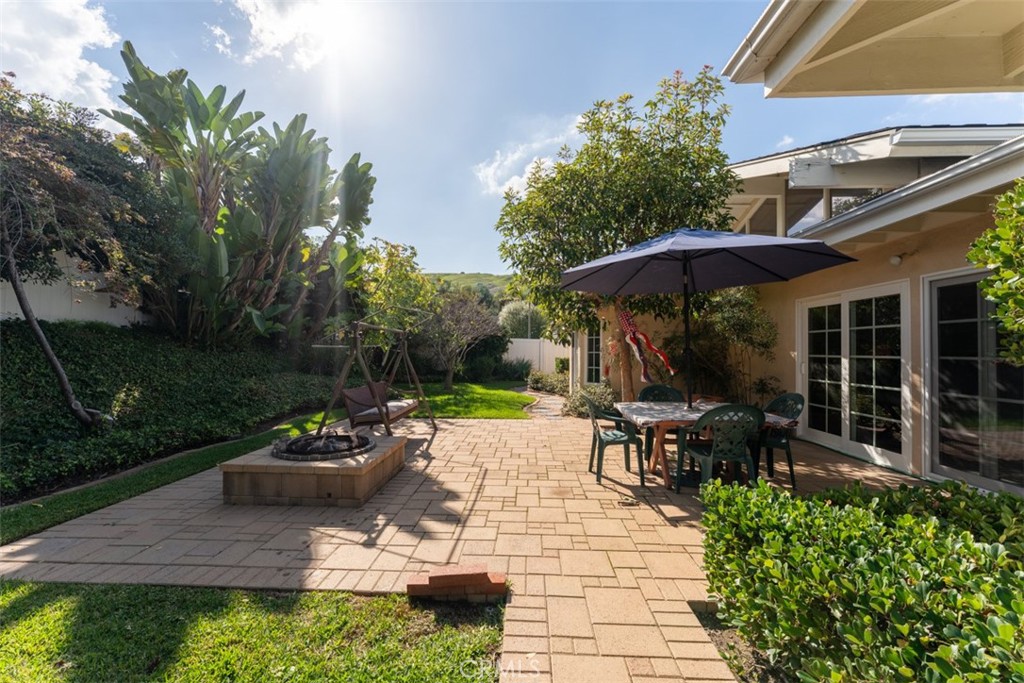 19512 Sierra Mia Road Irvine, CA 92603 - Photo 38 of 46 a view of a patio with a table and chairs under an umbrella