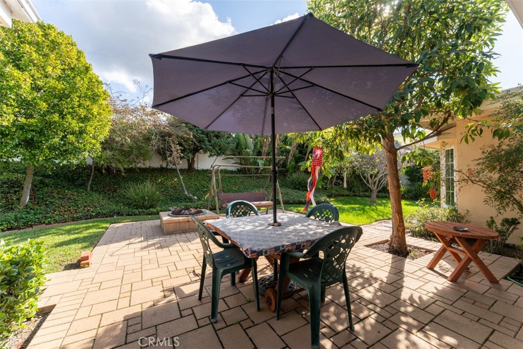 19512 Sierra Mia Road Irvine, CA 92603 - Photo 39 of 46 a view of patio with table and chairs under an umbrella