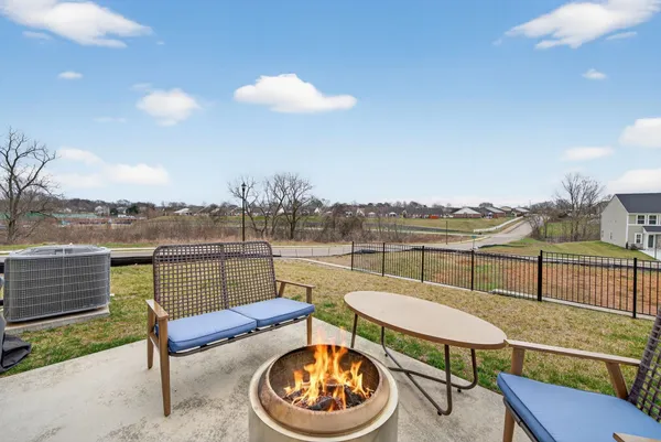 a view of a backyard with chairs and a patio