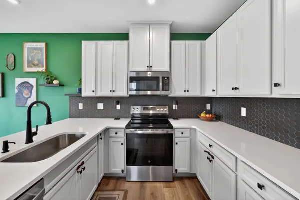 a kitchen with kitchen island a sink stainless steel appliances and cabinets