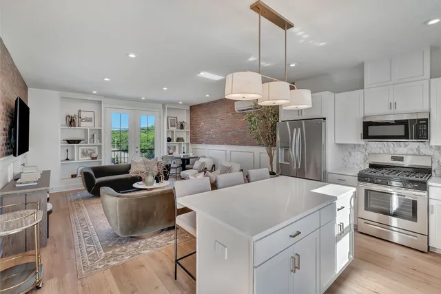 a kitchen with stainless steel appliances a stove a refrigerator a sink a stove a oven a dining table and chairs