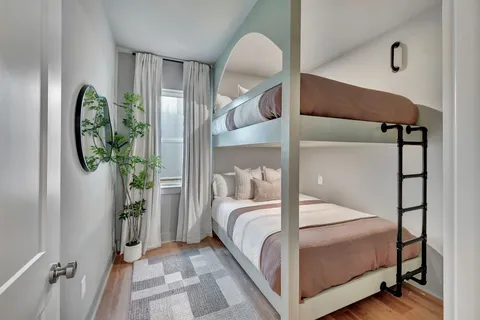 a bedroom with a bed a mirror and a window