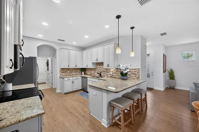 a kitchen with stainless steel appliances granite countertop a refrigerator and a stove top oven