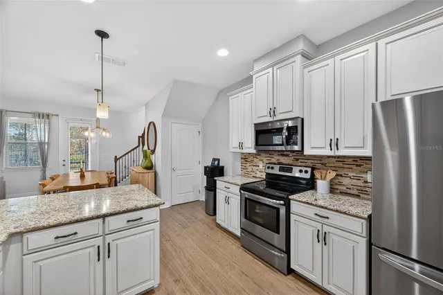 a kitchen with stainless steel appliances granite countertop a sink refrigerator and microwave