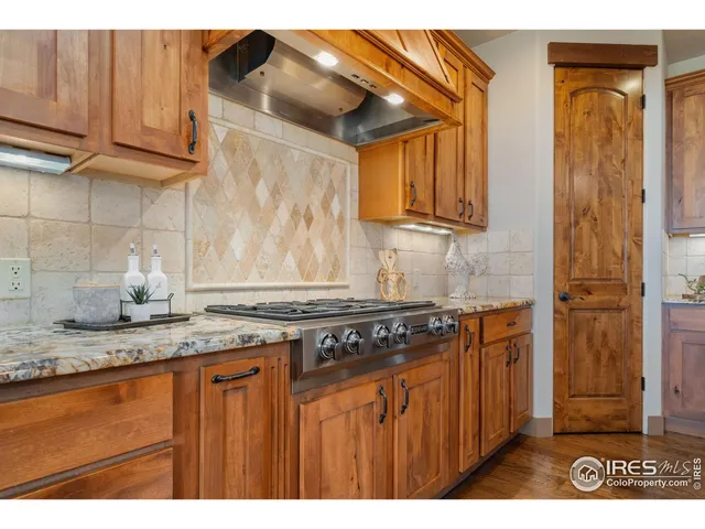 a kitchen with kitchen island granite countertop a stove a sink and a cabinets