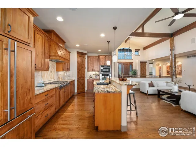 a kitchen with granite countertop a sink and living room view