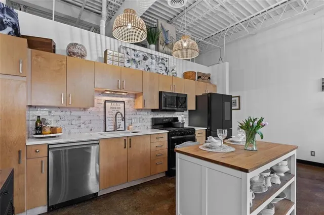 a kitchen with stainless steel appliances granite countertop a sink a stove and cabinets