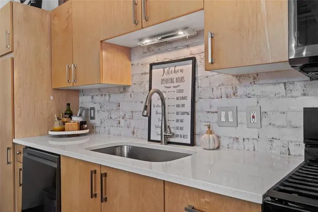 a kitchen with stainless steel appliances granite countertop a sink stove and cabinets