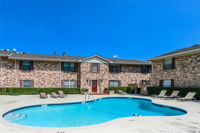 a view of house with swimming pool outdoor seating and house in the background
