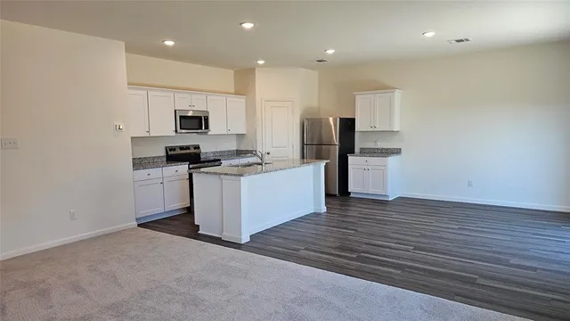 a kitchen with stainless steel appliances a refrigerator and a stove top oven