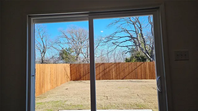 a view of a yard with trees in the background