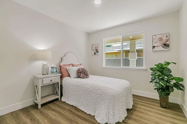 a bedroom with a bed and a potted plant
