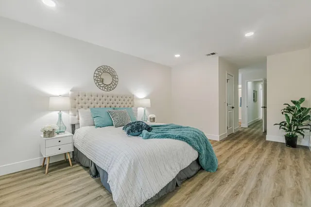 a bedroom with a bed and a potted plant