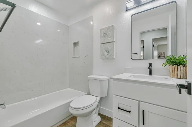 a bathroom with a sink toilet vanity and tub