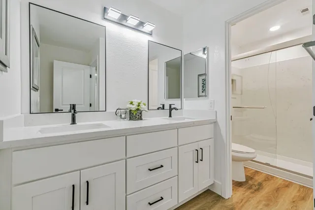 a bathroom with a double vanity sink toilet and shower