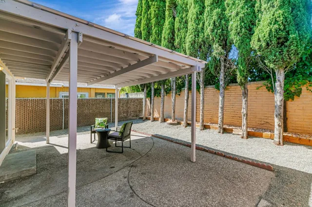 a view of a patio with table and chairs under an umbrella