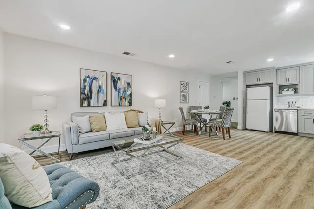 a living room with furniture and kitchen view