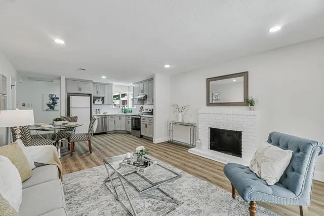 a living room with furniture kitchen view and a fireplace