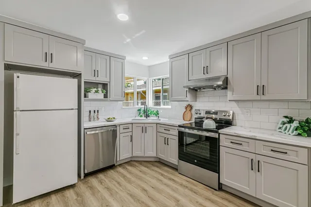 a kitchen with white cabinets and white appliances