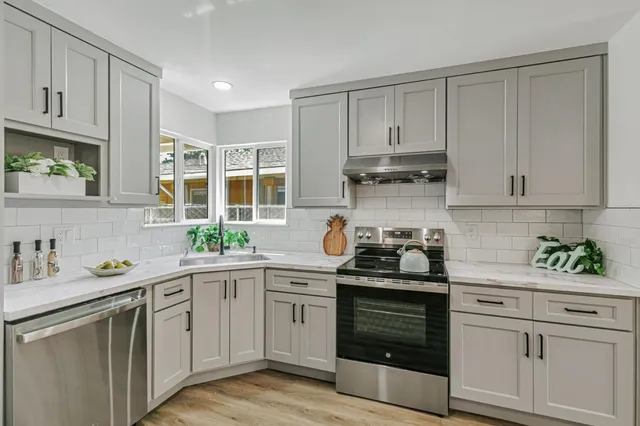 a kitchen with stainless steel appliances granite countertop a sink stove and cabinets