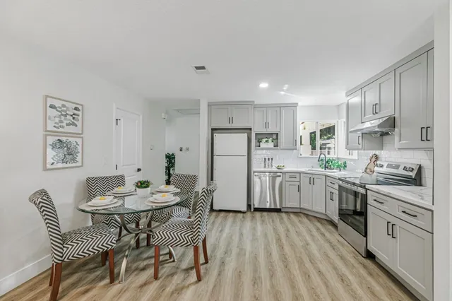 a kitchen with white cabinets and white appliances