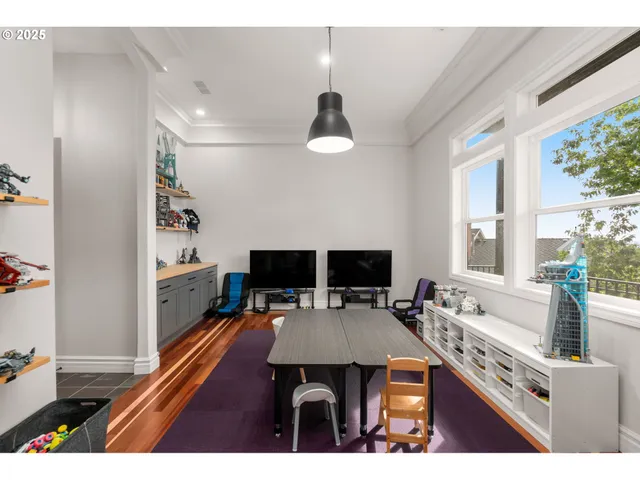 a living room with a table chairs and a flat screen tv