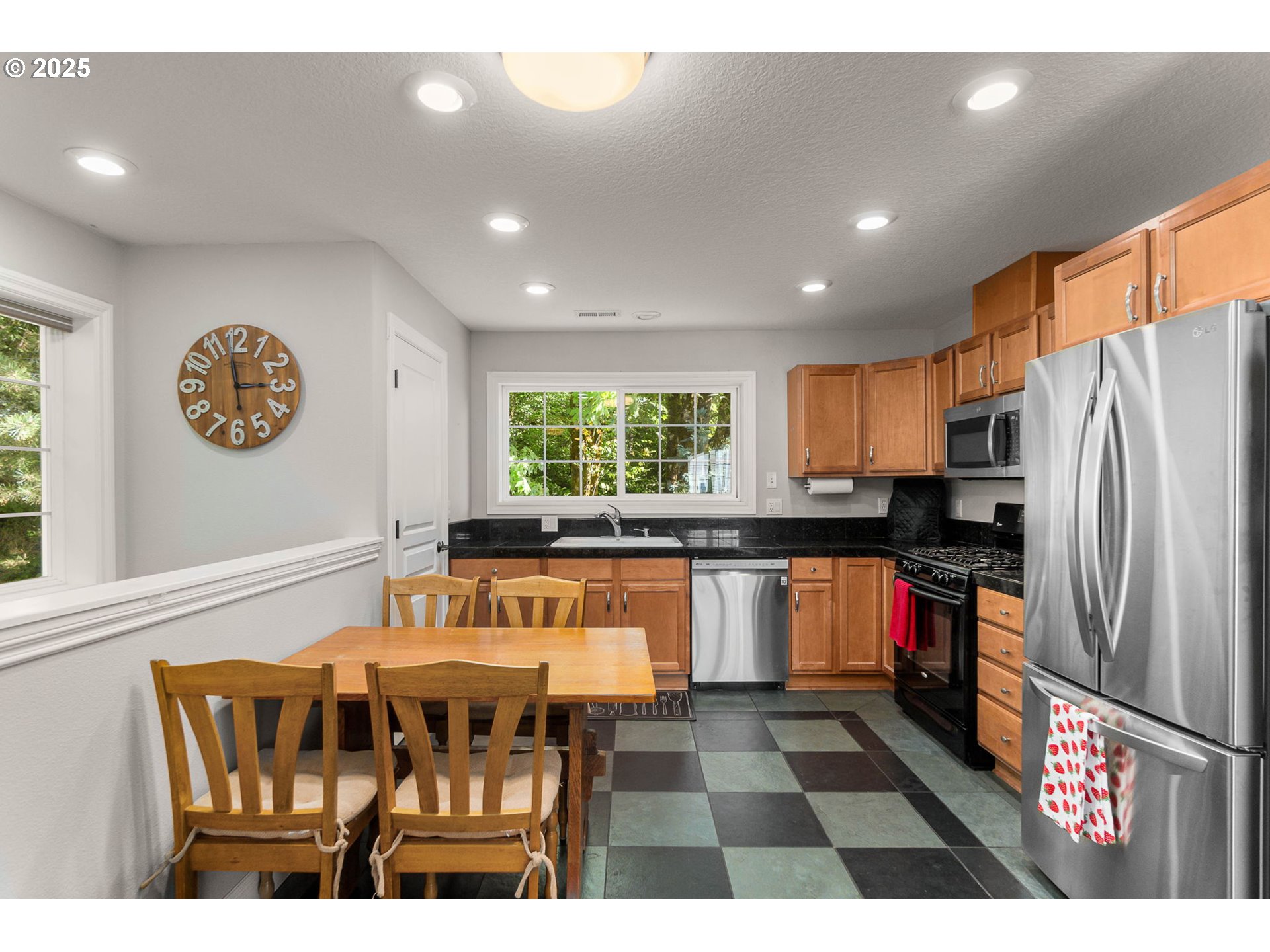 3720 Northwest Devoto Lane Portland, OR 97229 - Photo 35 of 44 a open kitchen with stainless steel appliances granite countertop a stove top oven a refrigerator and a dining table