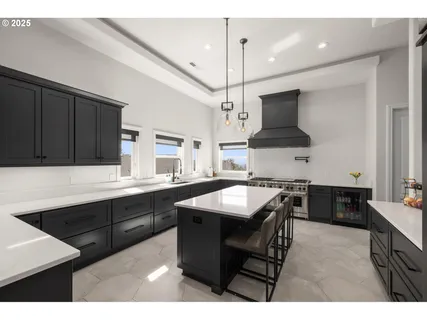 a kitchen with stainless steel appliances granite countertop a sink a stove and a refrigerator