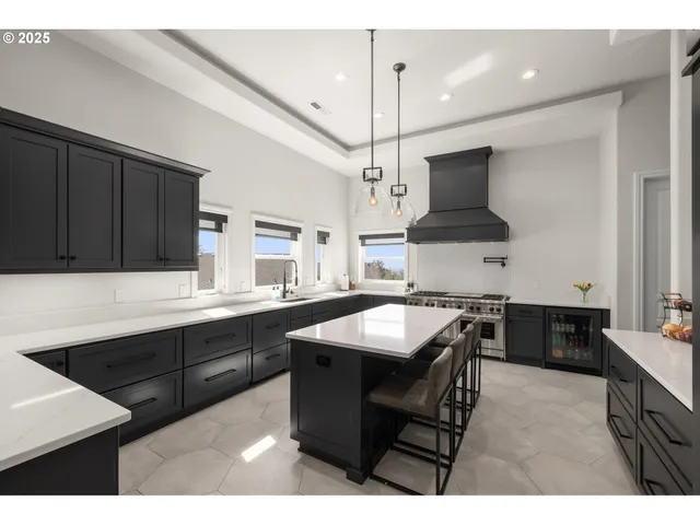 a kitchen with stainless steel appliances granite countertop a sink a stove and a refrigerator