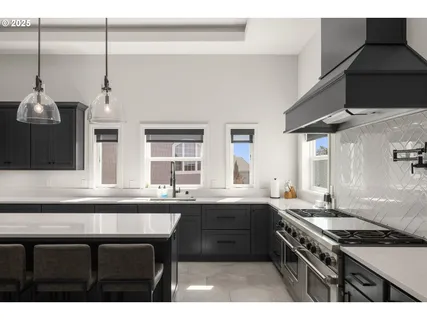 a kitchen with stainless steel appliances a sink stove and cabinets