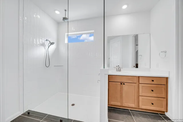 a bathroom with a shower sink and mirror