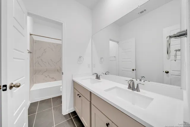 a bathroom with a bathtub shower sink vanity and toilet