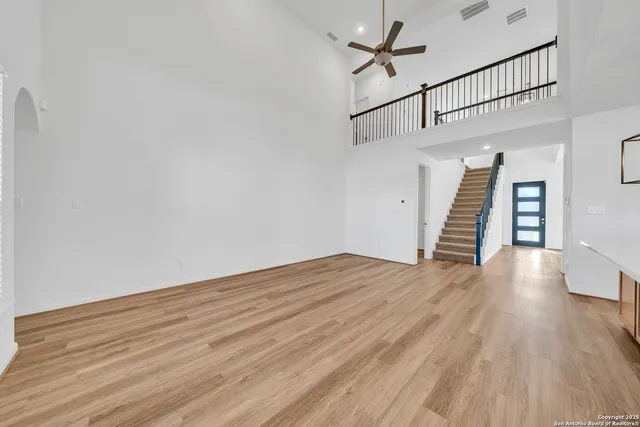 a view of a hallway with wooden floor and stairs