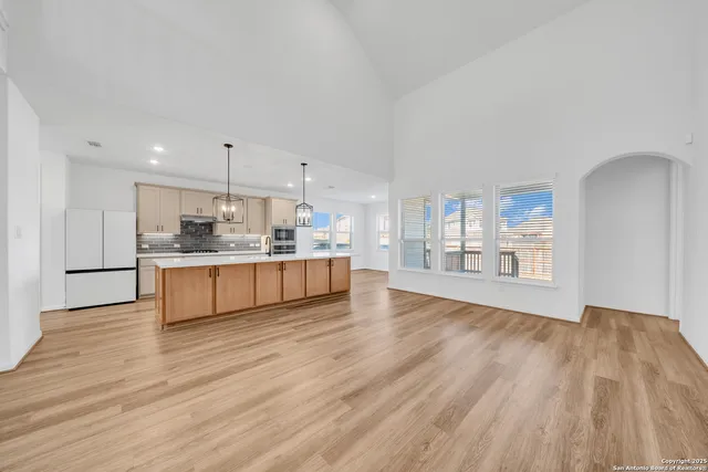 a large kitchen with cabinets wooden floor and a sink