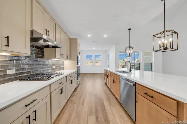 a large kitchen with stainless steel appliances lots of counter space and wooden floor