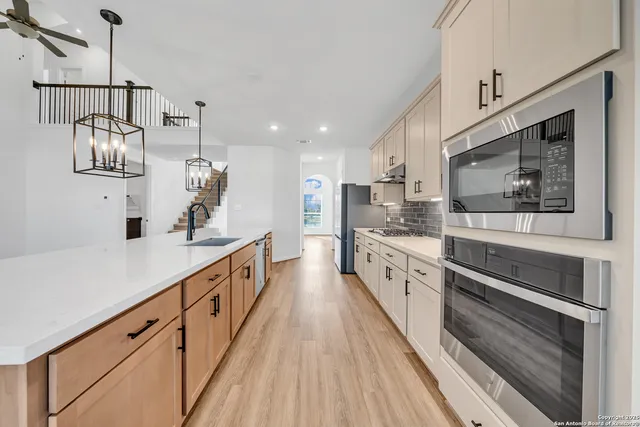 a large kitchen with cabinets and wooden floor
