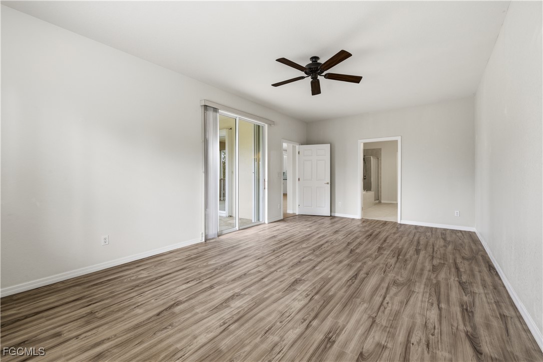 14951 Reflection Key Circle, Unit 536 Fort Myers, FL 33907 - Photo 12 of 36 a view of empty room with wooden floor and fan